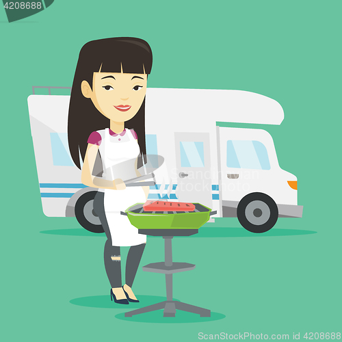 Image of Woman having barbecue in front of camper van.