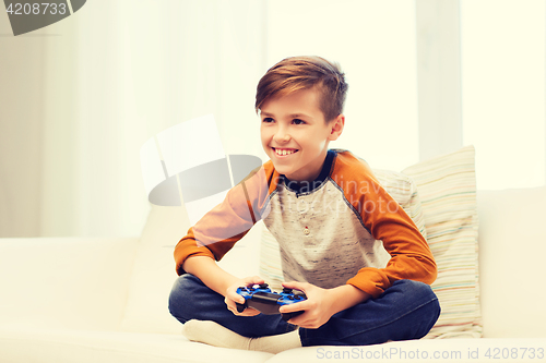 Image of happy boy with joystick playing video game at home