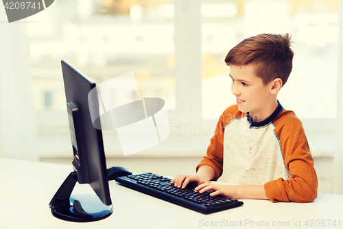 Image of smiling boy with computer at home
