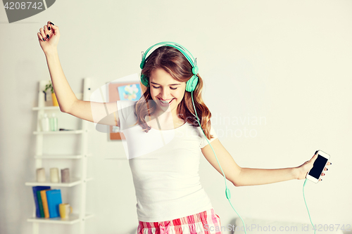 Image of happy woman in headphones ihaving fun at home