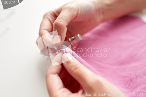 Image of woman with needle stitching fabric pieces