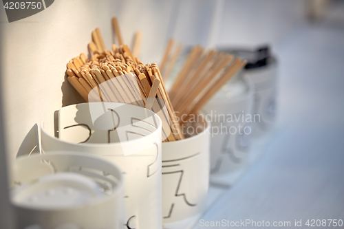 Image of wooden drink stirrers in holder on table