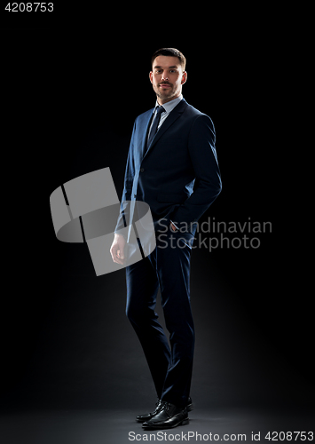 Image of businessman in suit over black