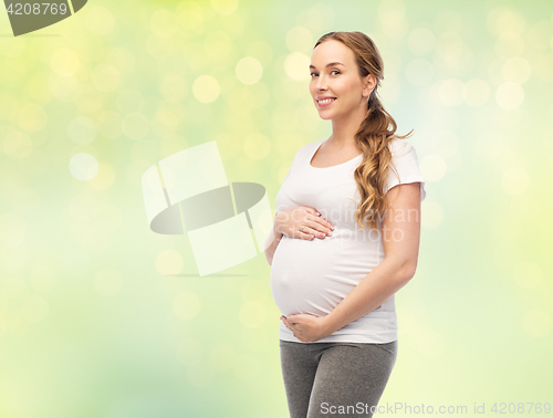 Image of happy pregnant woman touching her big belly