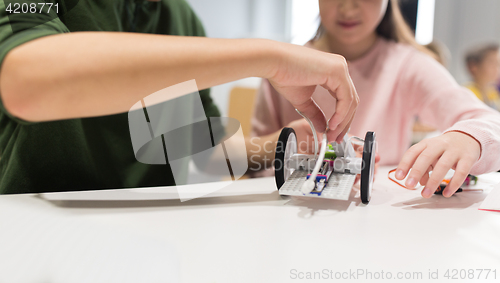 Image of happy children building robots at robotics school