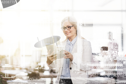 Image of smiling businesswoman with tablet pc at office