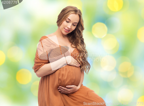 Image of happy pregnant woman touching her big belly