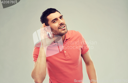 Image of man having hearing problem listening to something