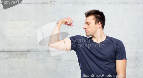 Image of sportive man showing bicep power