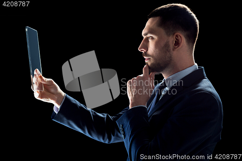 Image of businessman in suit working with transparent tablet pc