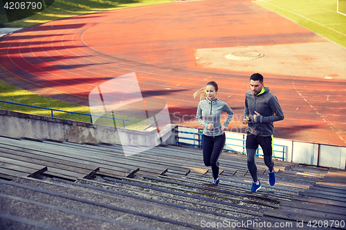Image of happy couple running upstairs on stadium