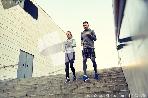 Image of happy couple running downstairs in city