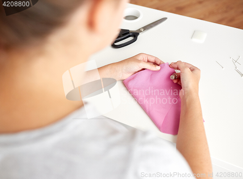 Image of woman with needle stitching fabric pieces