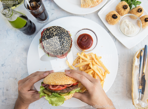 Image of Man eating burgers