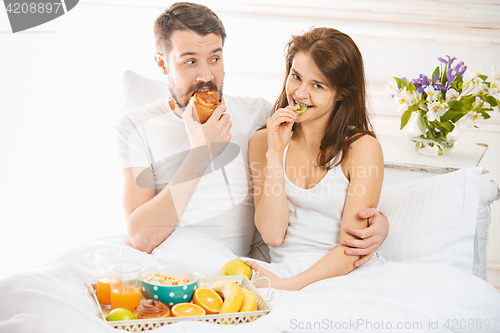 Image of Relaxed Couple in Bed in bedroom at home