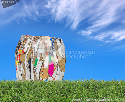 Image of Pressed boxes made of paperboard on the meadow with blue sky in 