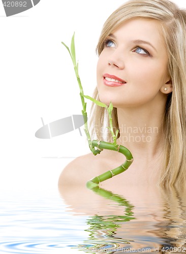 Image of blue-eyed blonde with bamboo in water