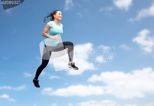 Image of happy smiling sporty young woman jumping in air