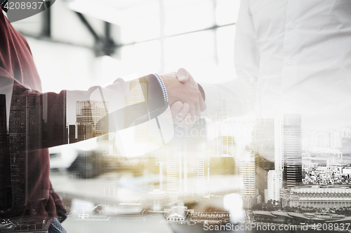 Image of businessmen making handshake at office