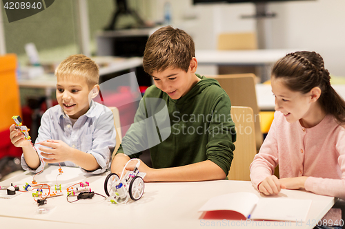 Image of happy children building robots at robotics school