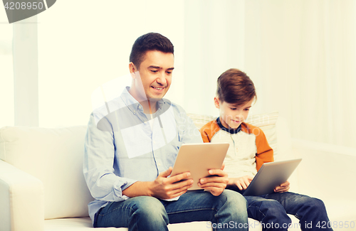 Image of happy father and son with tablet pc at home