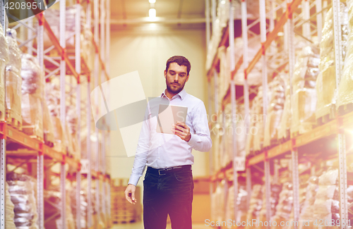 Image of businessman with tablet pc at warehouse