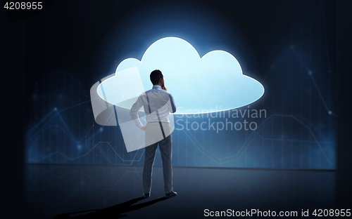 Image of businessman at cloud projection over dark