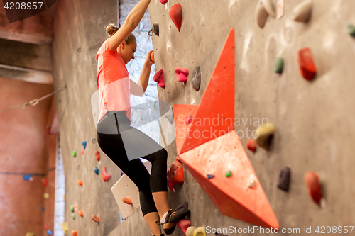 Image of young woman exercising at indoor climbing gym