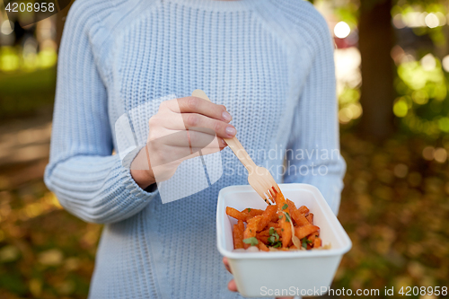 Image of close up of hand holding plate with sweet potato