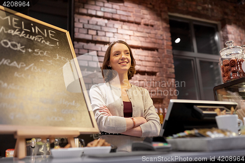 Image of happy woman or barmaid at cafe counter