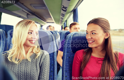 Image of happy young women talking in travel bus