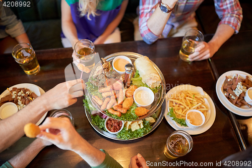Image of friends eating and drinking at bar or pub