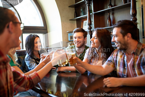 Image of happy friends drinking beer at bar or pub