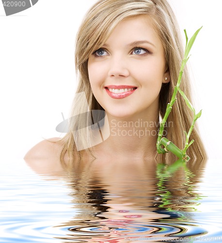 Image of blue-eyed blonde with bamboo in water