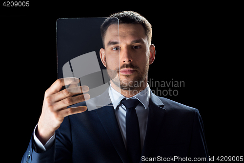 Image of businessman in suit working with transparent tablet pc