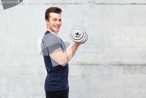Image of happy sportive young man with dumbbell