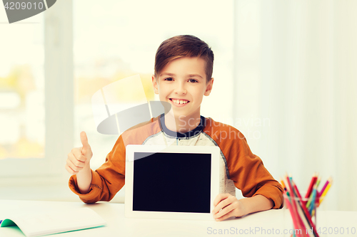 Image of happy boy with tablet pc showing thumbs up at home