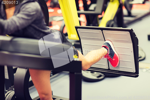 Image of woman flexing muscles on leg press machine in gym