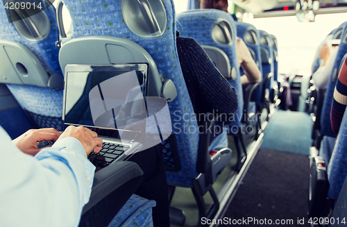 Image of man with smartphone and laptop in travel bus