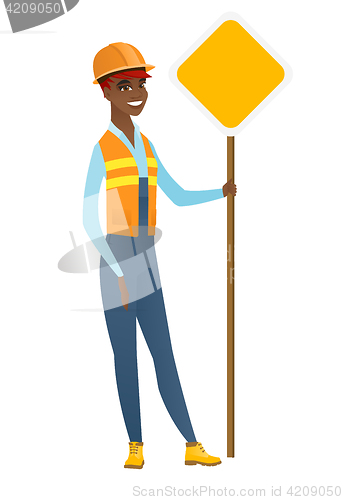 Image of African-american road worker showing road sign.