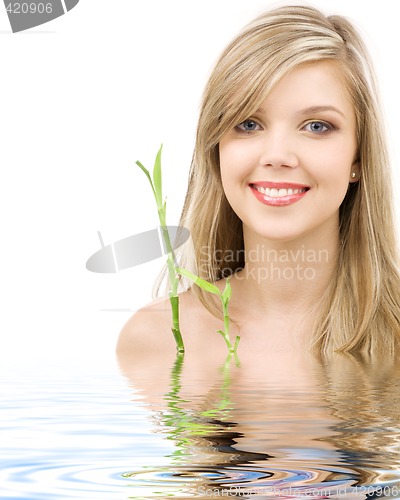 Image of blue-eyed blonde with bamboo in water