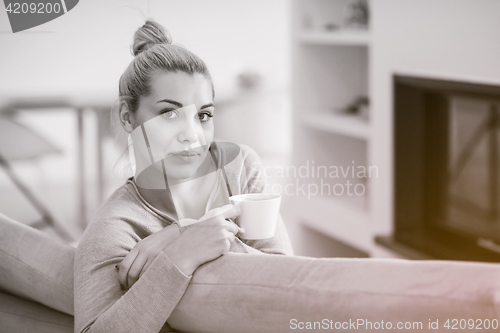 Image of woman with a mug near a fireplace