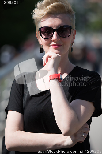 Image of young woman with short blond hair and sunglasses