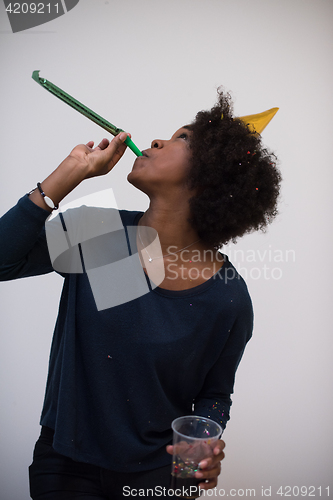 Image of black woman in party hat blowing in whistle