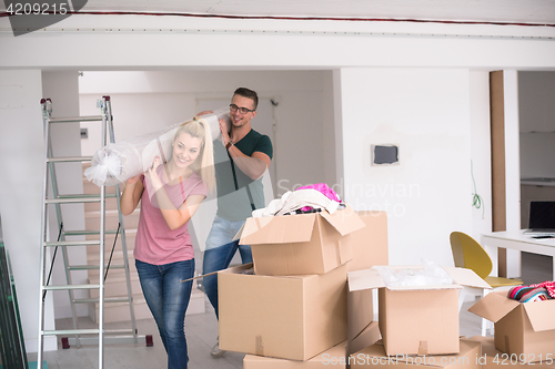 Image of couple carrying a carpet moving in to new home