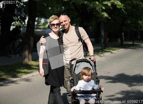 Image of couple with baby pram in summer park