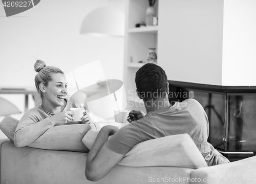 Image of Young multiethnic couple  in front of fireplace