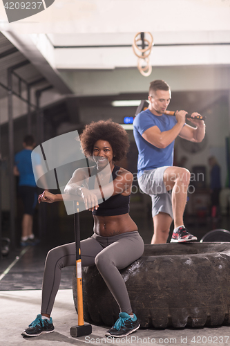 Image of multiethnic couple after workout with hammer