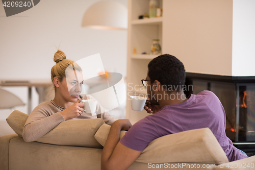 Image of Young multiethnic couple  in front of fireplace