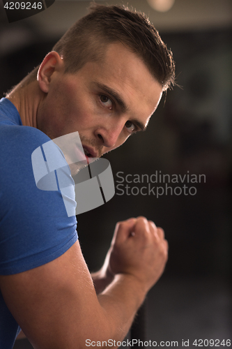 Image of man workout with hammer and tractor tire